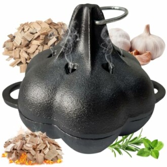 Cast iron garlic roaster with wood chips and garlic cloves.