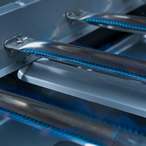 Close-up of gas grill burners with blue flames.