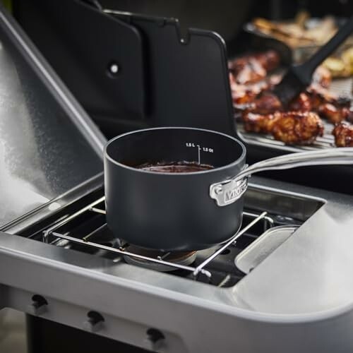 Saucepan on outdoor grill with meat cooking