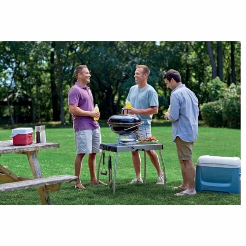 Three men socializing around a barbecue grill in a backyard.