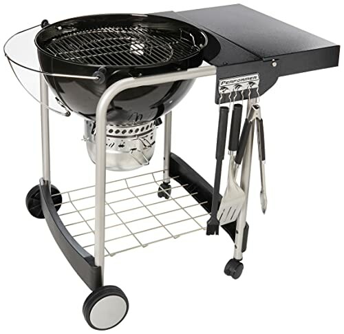 A Charcoal grill with side table and utensils.