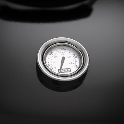 Close-up of a grill thermometer on a black surface