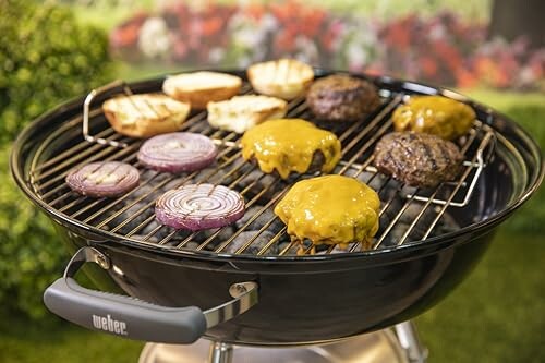 Grill with burgers, onions, and buns.