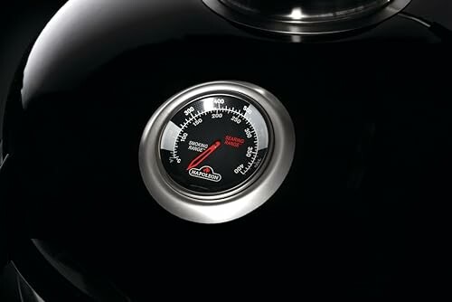 Close-up of a smoker temperature gauge on a grill.